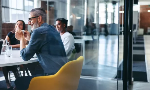 cheerful businessman attending a meeting with his team